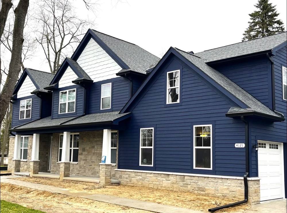 Navy blue new construction home with black gutters and soffit